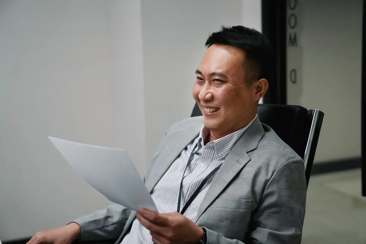Manager reading through a printed invoice at his desk