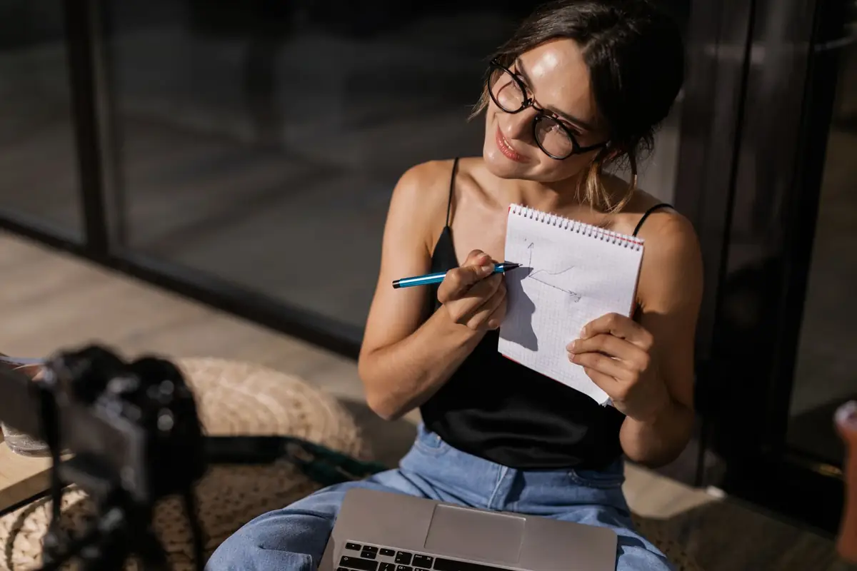 Content creator planning a campaign with a notebook and camera