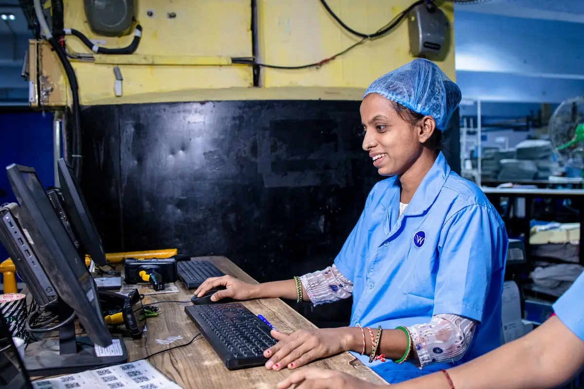 Operations worker entering data at a computer on the production floor